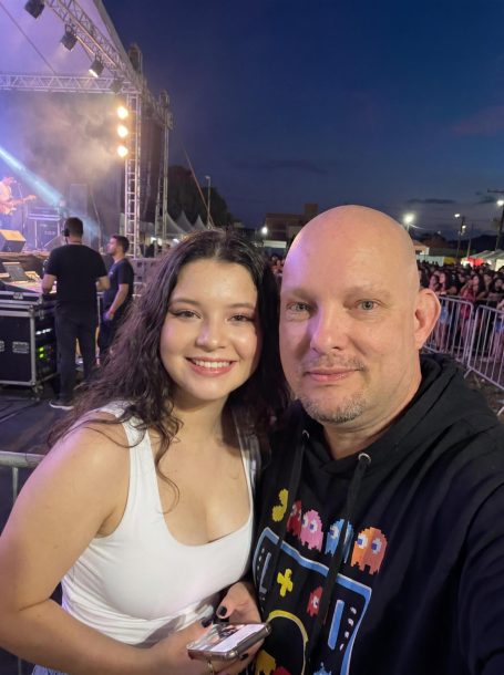 Ellie mit Jürgen Sester Ein Mann und eine Frau lächeln in einem Festival-Setting, mit Bühnenlichtern im Hintergrund.